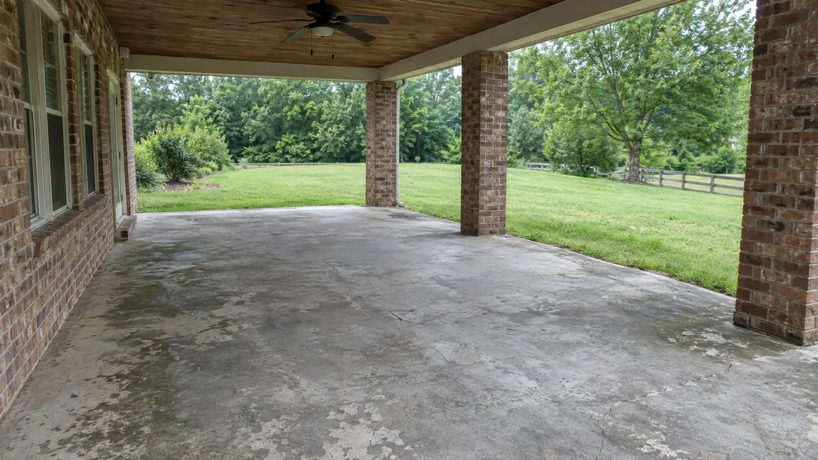 Patio and porch with worn, stained bare concrete before coating