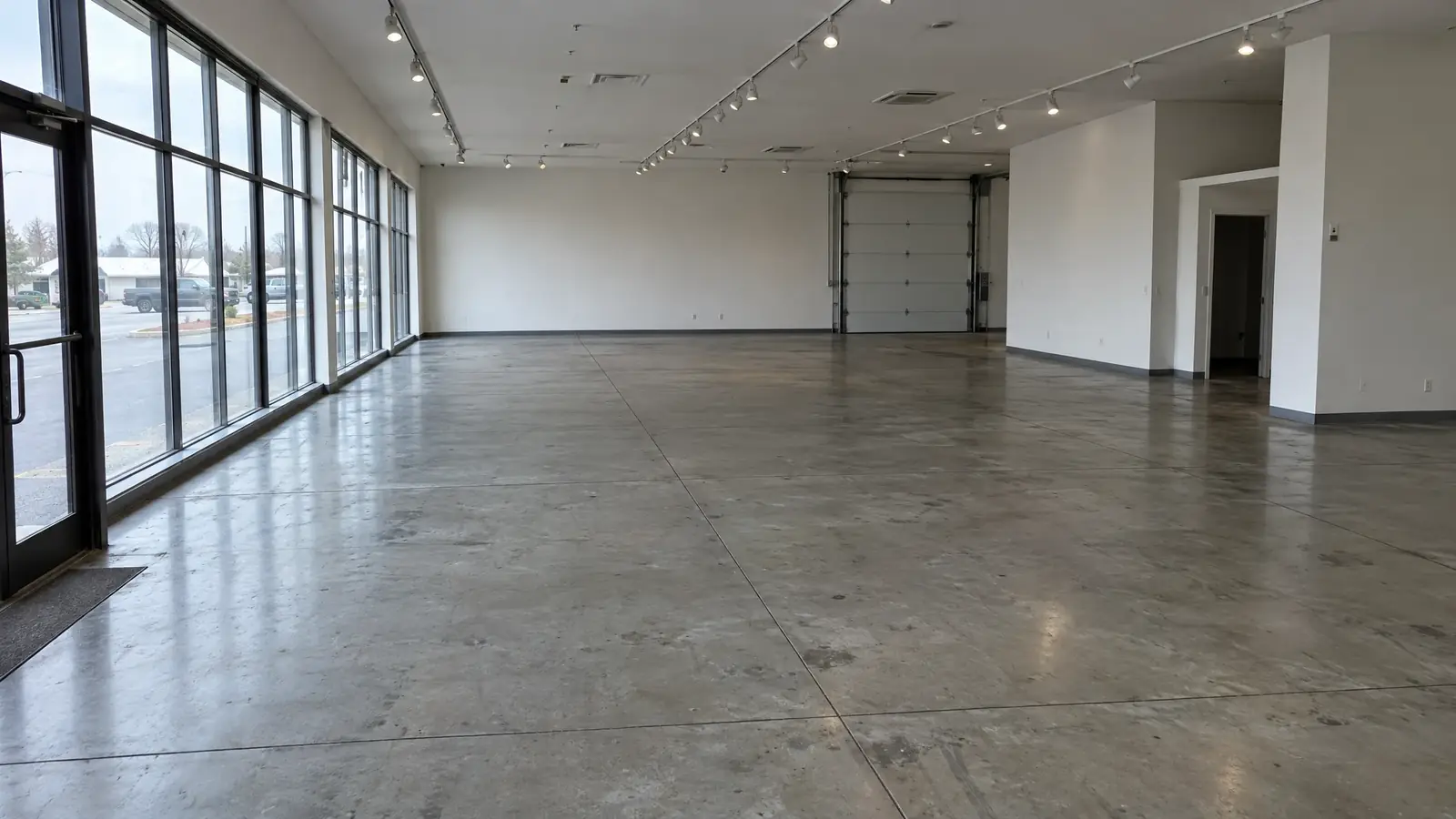 Showroom with worn, stained bare concrete before coating